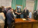 Governor Charlie Baker shakes hands with Cheryl Ryan Chan after signing Nicky's Law