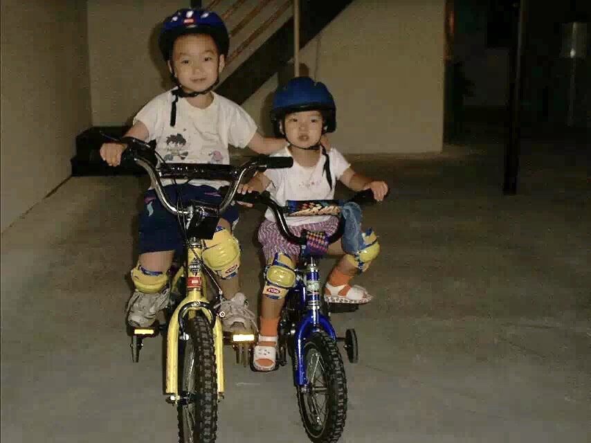Older brother (left) + baby Jessie, learning to bike in the basement