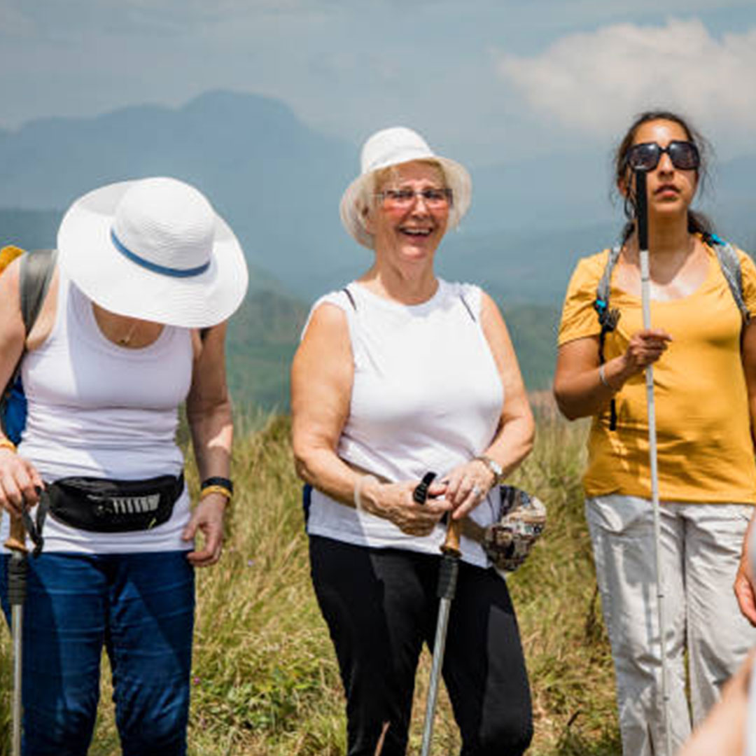 A group of women, including some with limited vision, hike with white canes.